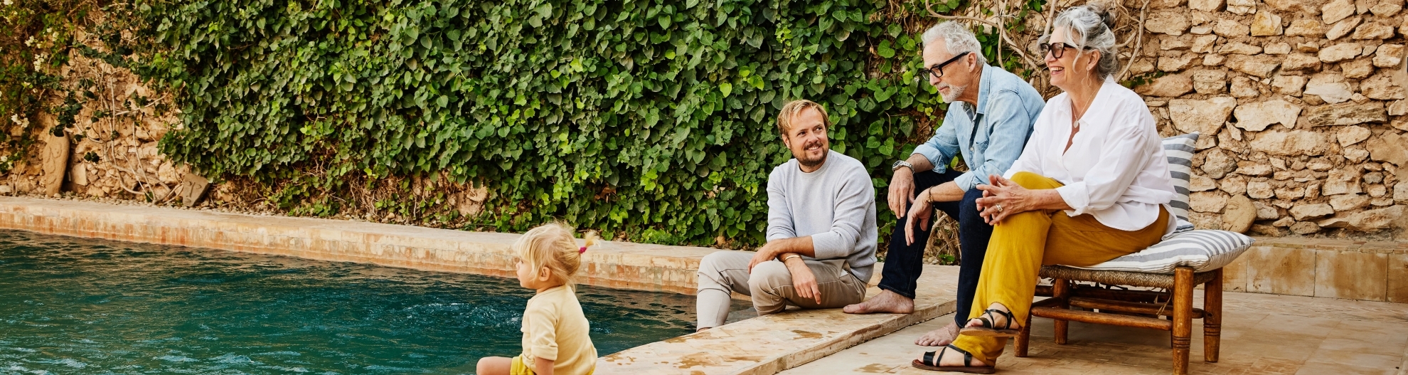 Smiling Multigenerational Family Relaxing At Tropical Villa Pool